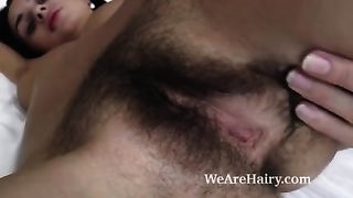 Испанка с красивой фигурой раздевается и гладит мохнатую киску в постели